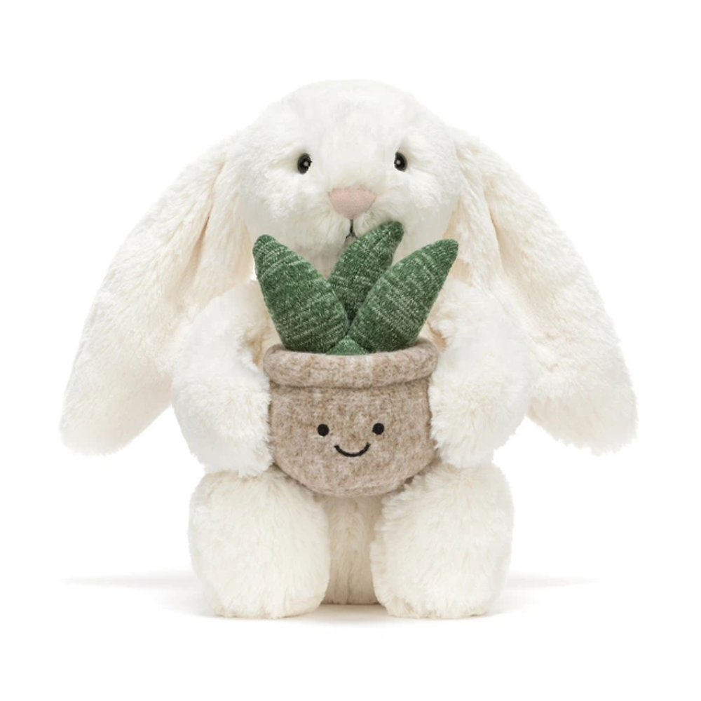 Peluche lapin crème tenant une plante